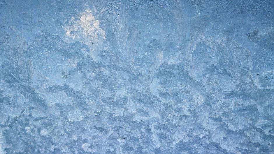 Blauwe lucht en ijs op de ruit