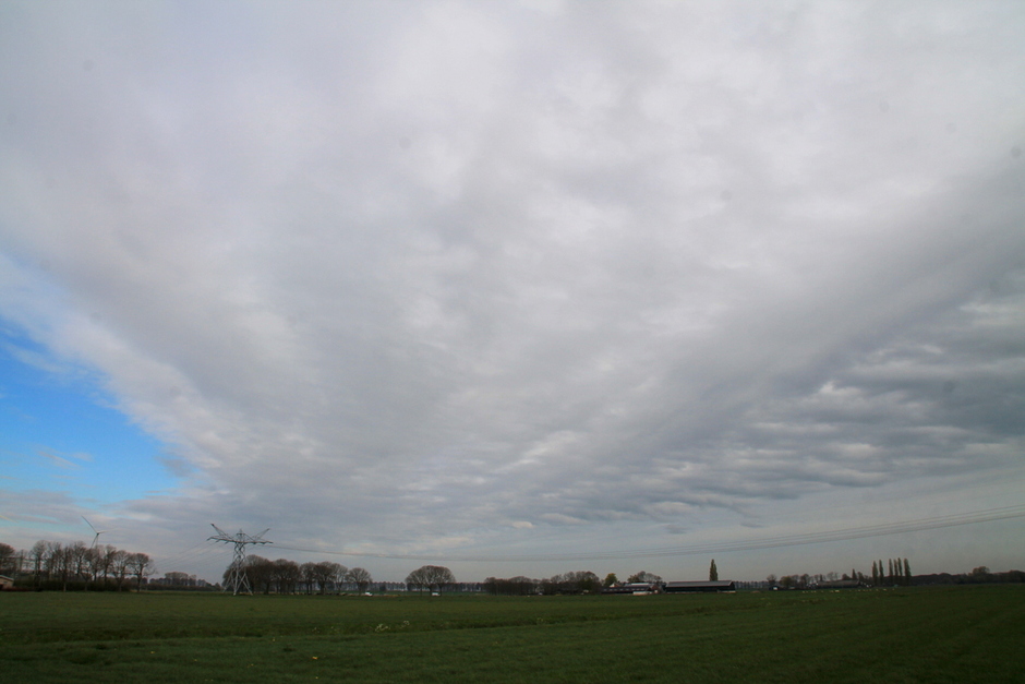 een wolkenband trekt over de polder