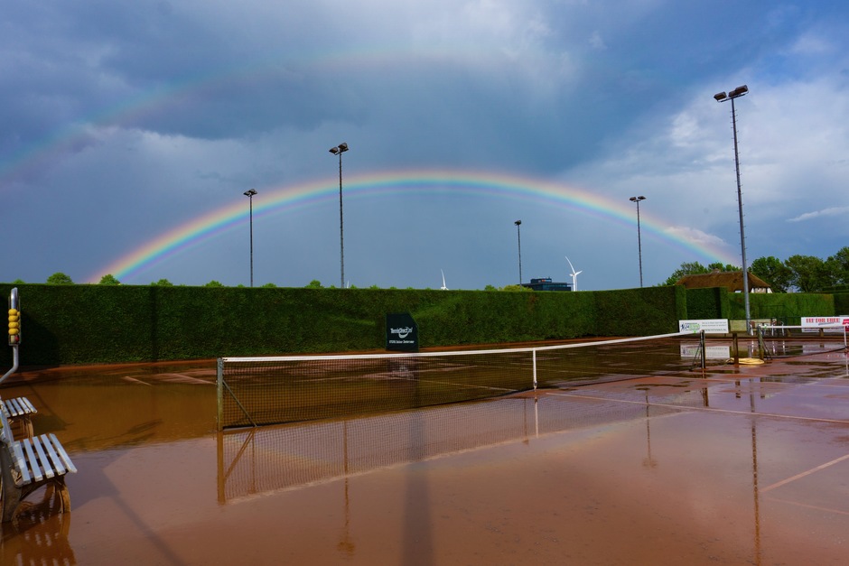 Regenboog boven tennisbaan