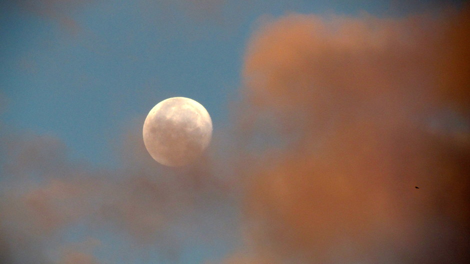 Kleurige wolken en de maan