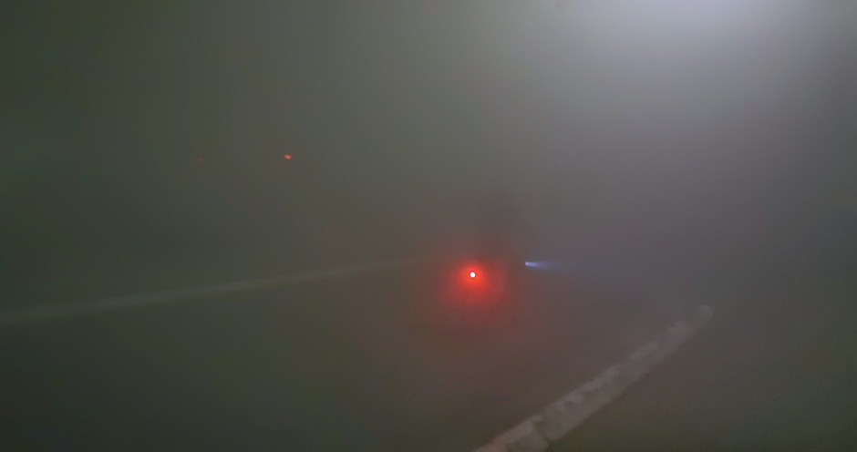 Fietser midden op de openbare weg tijdens de mist van vannacht. Net zichtbaar 