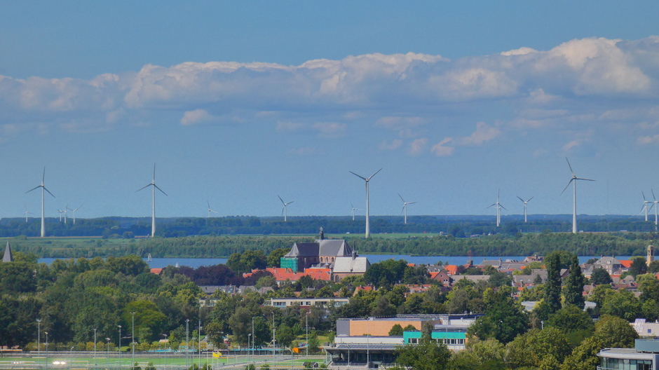 Over de "Grote Kerk" van Harderwijk zie je de windmolens van Flevoland 
