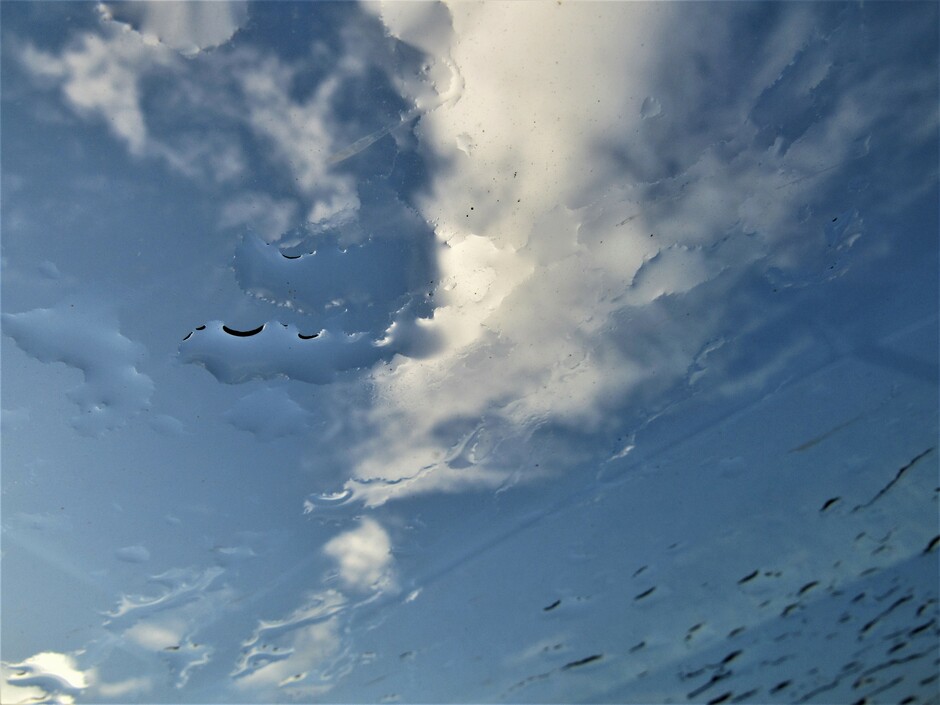 Regendruppels op het glazen dak van de auto vanuit de bestuurdersstoel