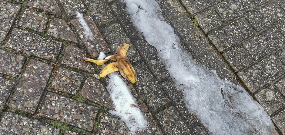 Uitglijden over de sneeuwdrab of een bananenschil 