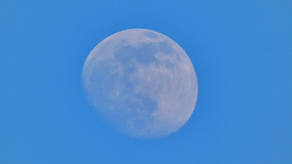 91% wassende maan tegen een strak blauwe lucht 