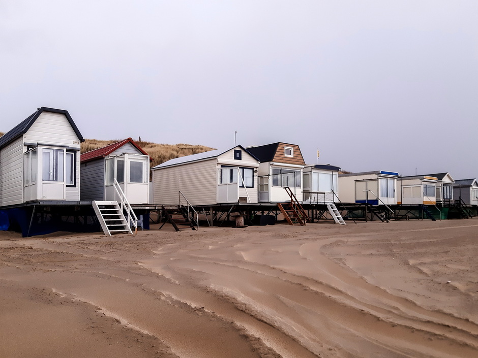 Grijs bewolkt verlaten strandhuisjes