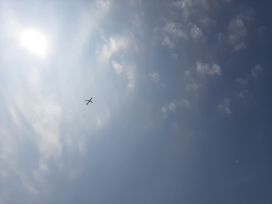 Wolkjes, blauwe lucht en een vliegtuig 