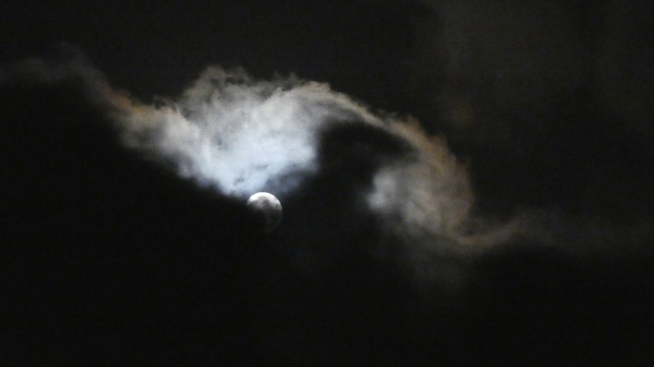 Maan achter wolken