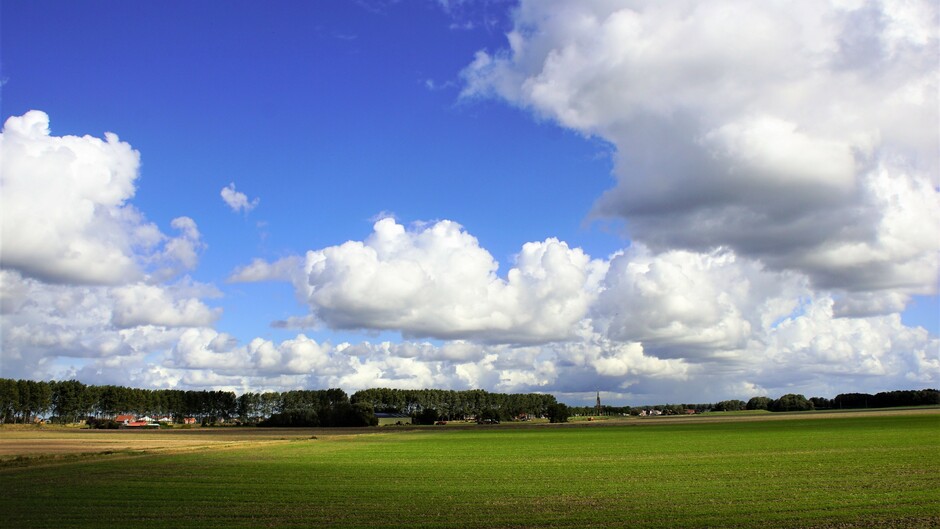 zon blauwe lucht mooie stapel wolken 14 gr in de polder
