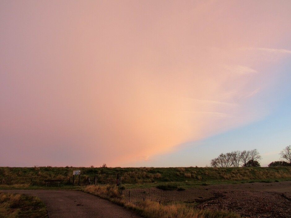 Een roze wolkendek vanmorgen tijdens en voor zonsopkomst, de opklaring is al te zien, boven aan de dijk bij Kats