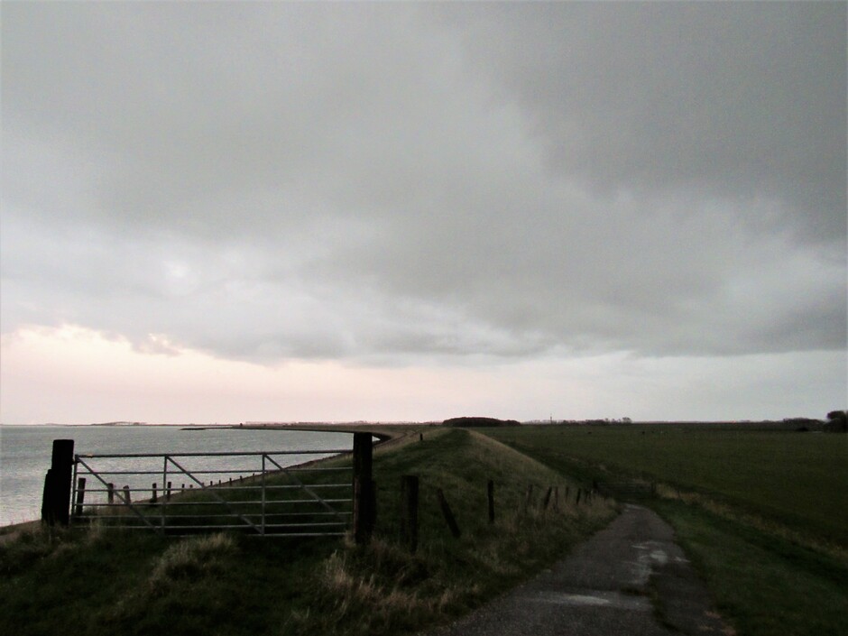 Donkere dreigende wolken trekken over de dijk bij Kats, dit is rond 8.00 uur, even later geen zon bij zonsopkomst te zien, wel een fikse plensbui