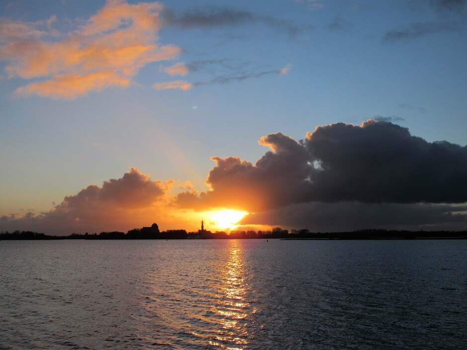 Na een grijze dag met in de middag opklaringen volgde toch nog een mooie zonsondergang, aan het Veerse-Meer bij Kamperland, met zicht op Veere, toen hij onder was volgde een regenbuitje