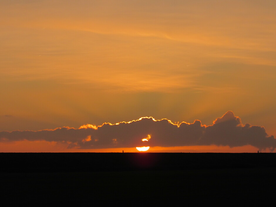 Zonsopkomst aan de dijk bij Kats, Zeeland, de zon verdwijnt voor heel even onder de wolk maar we zien hem nog steeds schijnen, het is nu 10.22 uur