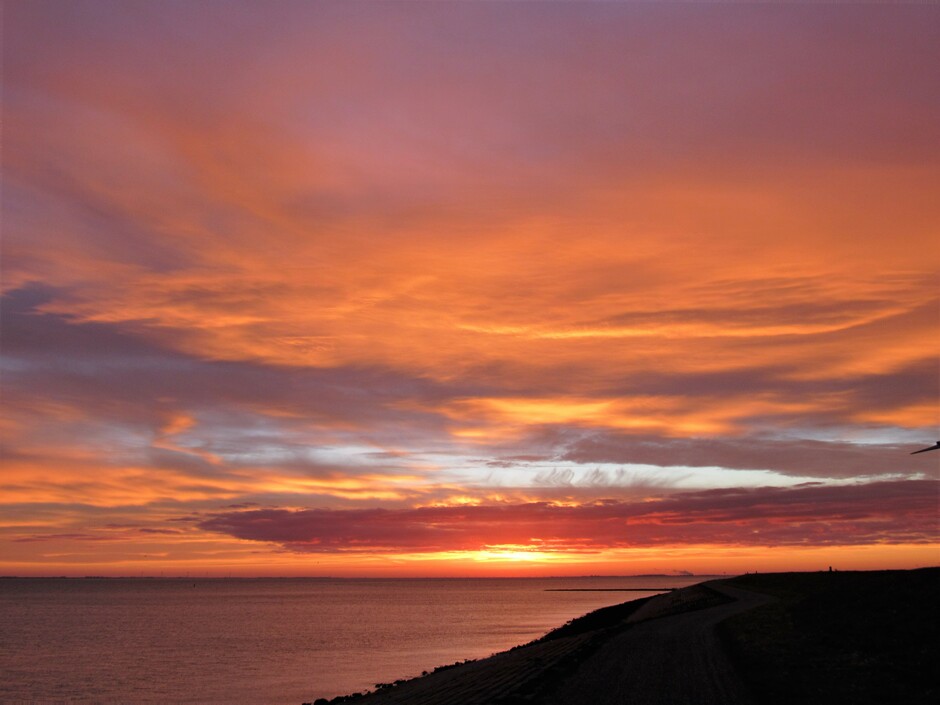 De laatste dag van het jaar begint met een kleurrijke zonsopkomst, bij Colijnsplaat, Zeeland