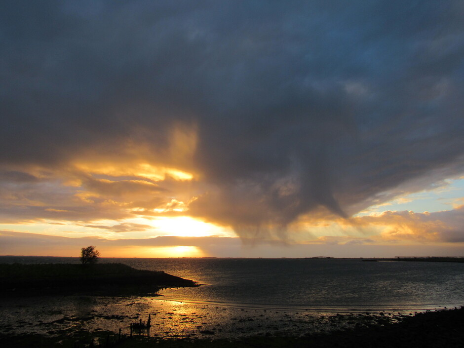 Zonsopkomst en neerslag uit de donkere wolk, bij Kats, Zeeland
