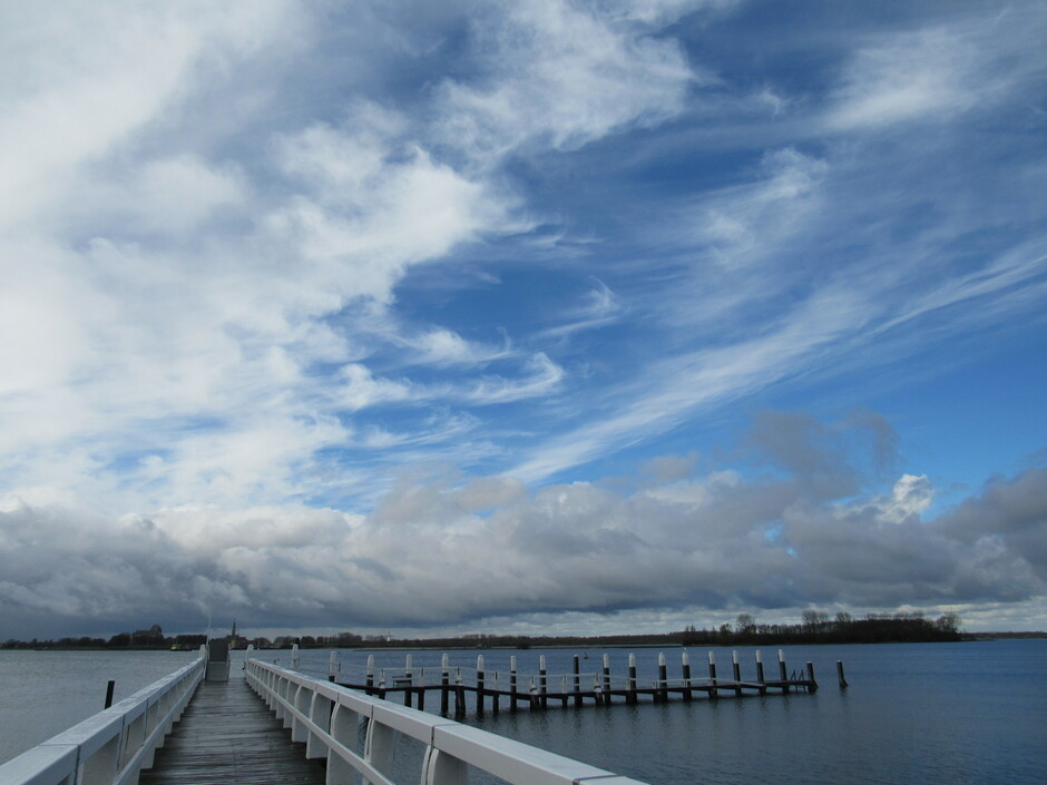 Na een regenbuitje prachtige wolkenluchten met vegen, zon en windstil bij het Veerse-Meer
