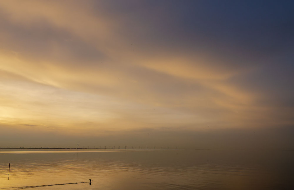  zonsondergang boven het IJsselmeer: Saharastof zorgt voor een warme gloed