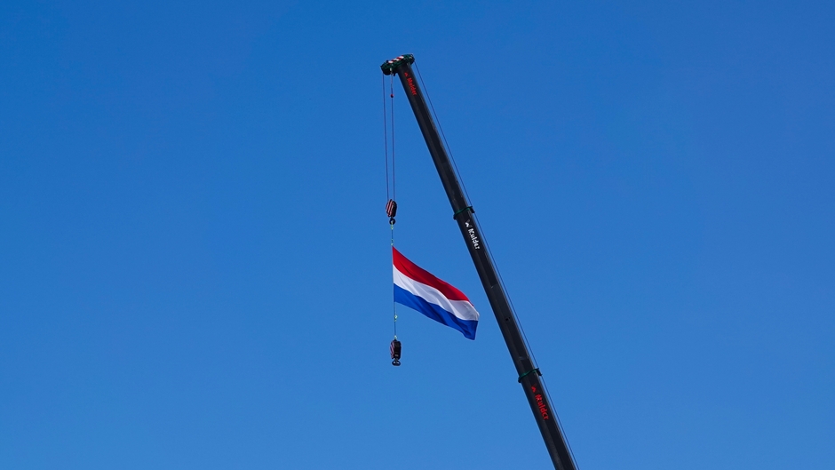 De vlag wappert bij een mooie blauwe lucht