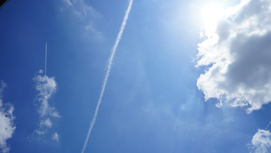 Zon, wolken en vliegtuigstrepen