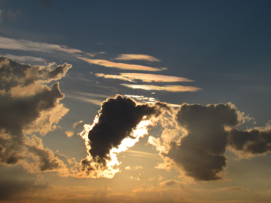 Nadat de zon opgekomen is verdwijnt die onder de wolk, boven de wolk zijn irisatiewolken te zien 