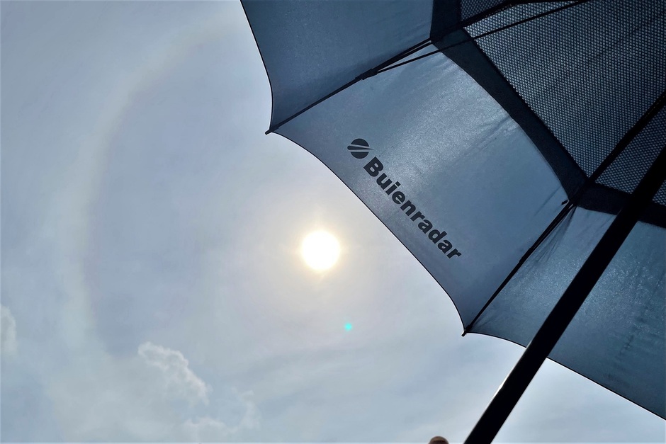 Zon en maan op 1 foto, halo paraplu, deemsterig aan de kust rustige zee gezellige stranddrukte