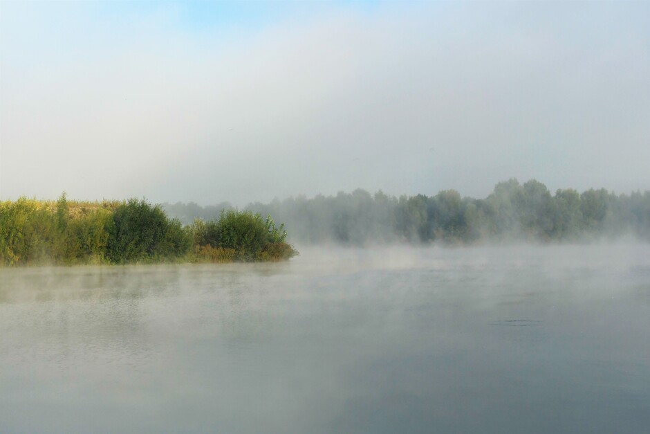 Dampende mist boven het water