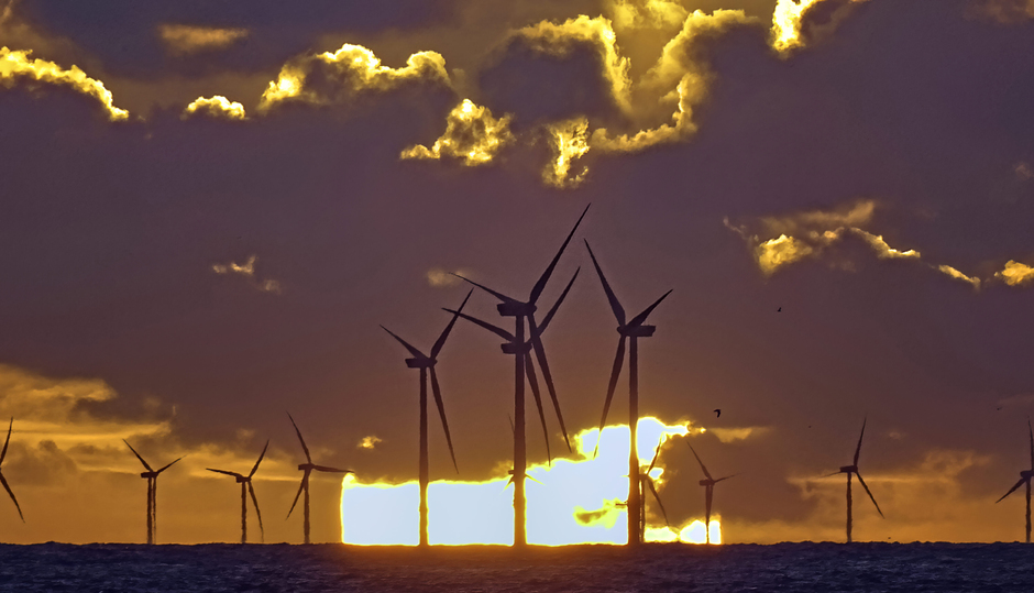 Zonsondergang achter het windmolenpark op zee 