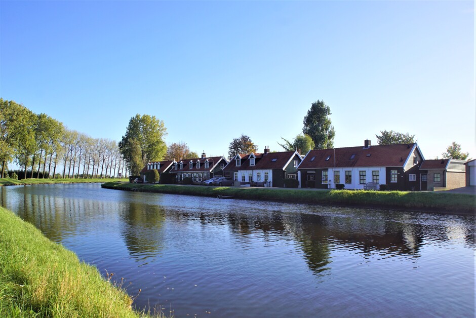 zonnig en strak blauwe lucht 14 gr op het kanaal met huisjes