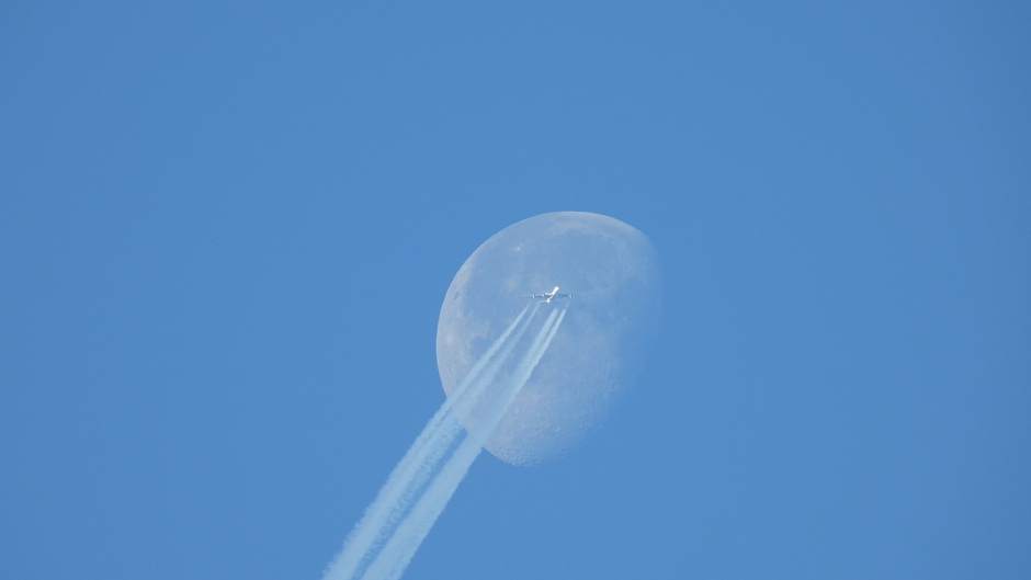 Een vliegtuig passeert de maan rond 11.00 uur