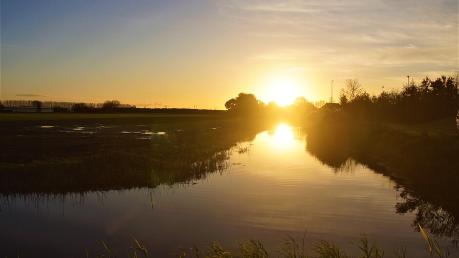 zonsopkomst 5 gr blauwe lucht in de polder met sloot