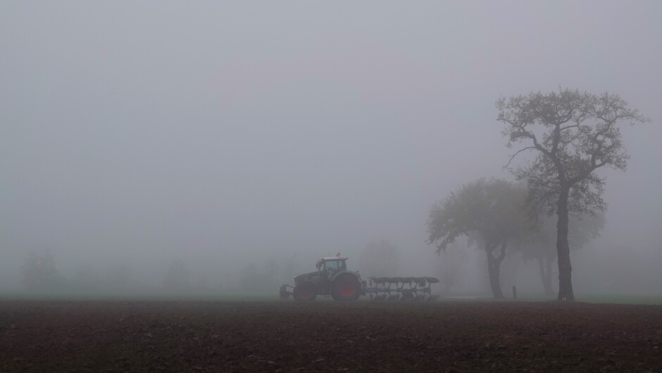 Boer op het land met mist