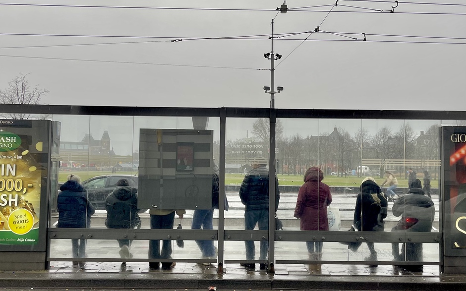 Wachten op de tram in de stromende regen
