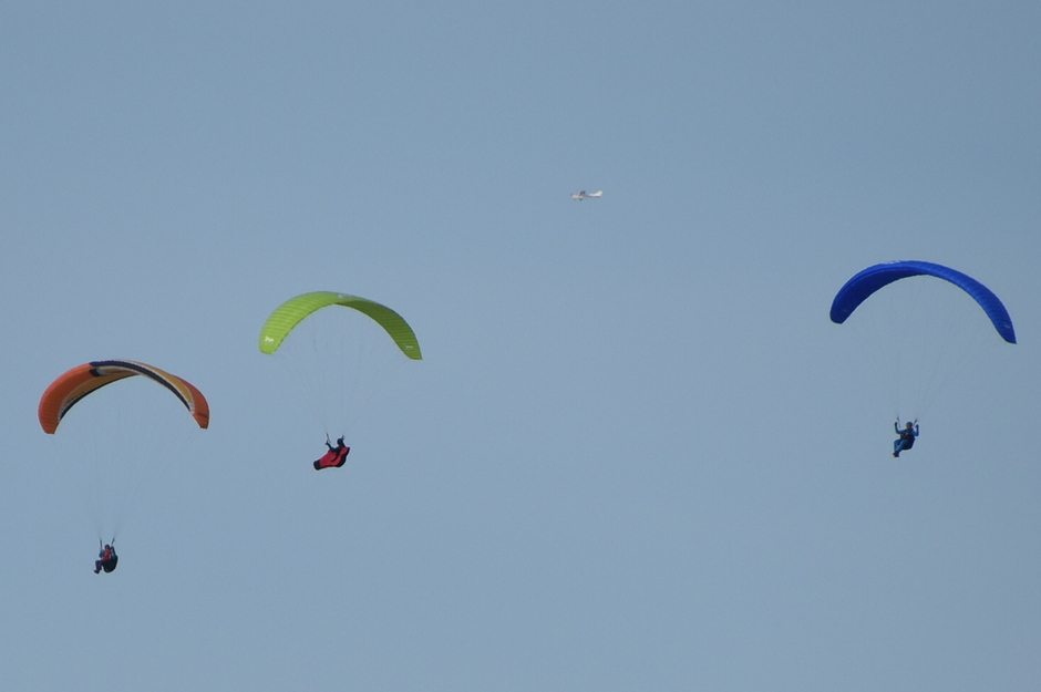 Drie paragliders en een vliegtuigje