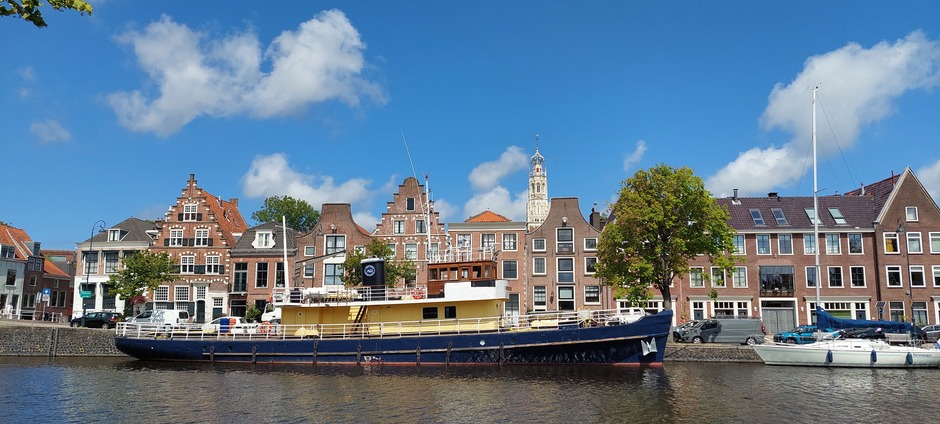 Sleepbootje aan het Spaarne in Haarlem blauwe lucht.