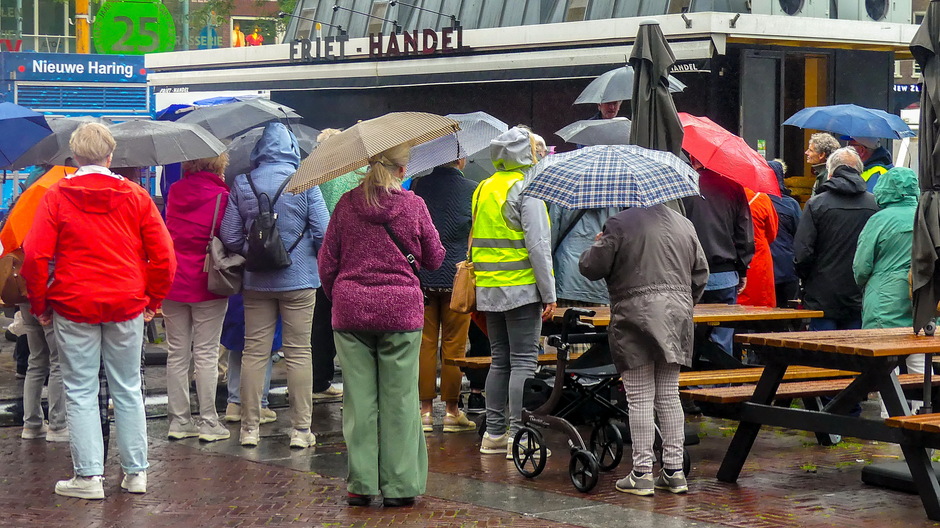 Parapluparade druilerig weer bij een stadsrondleiding