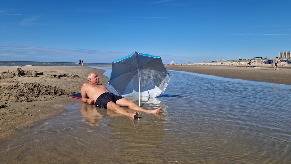 Prachtige stranddag aan Zee, parasol tegen de uv stralen of toch de wind?