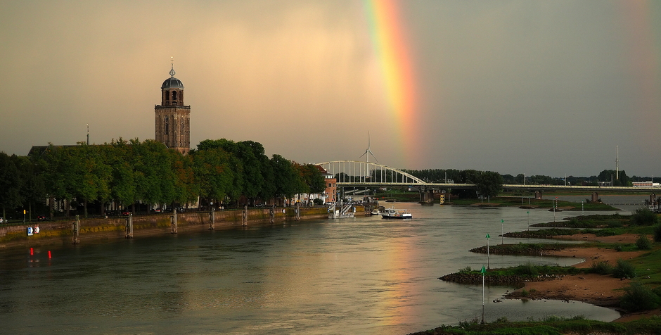 Weerspiegeling van de regenboog in de IJssel