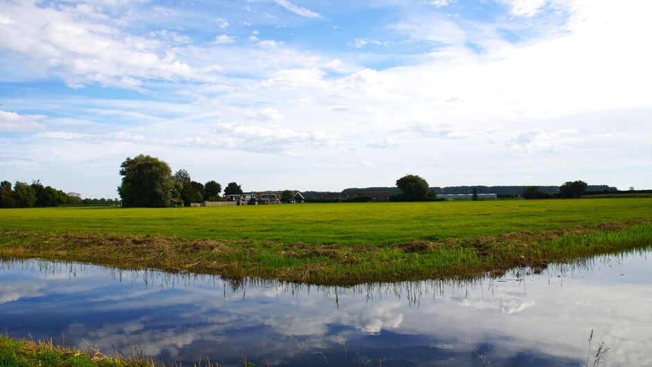 zon blauw wolken 18 gr in de polder met weerspiegeling