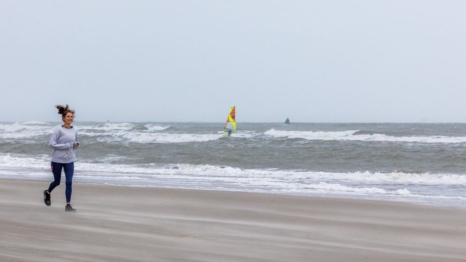 Jogger en surfers Noordzeestrand Vlieland.