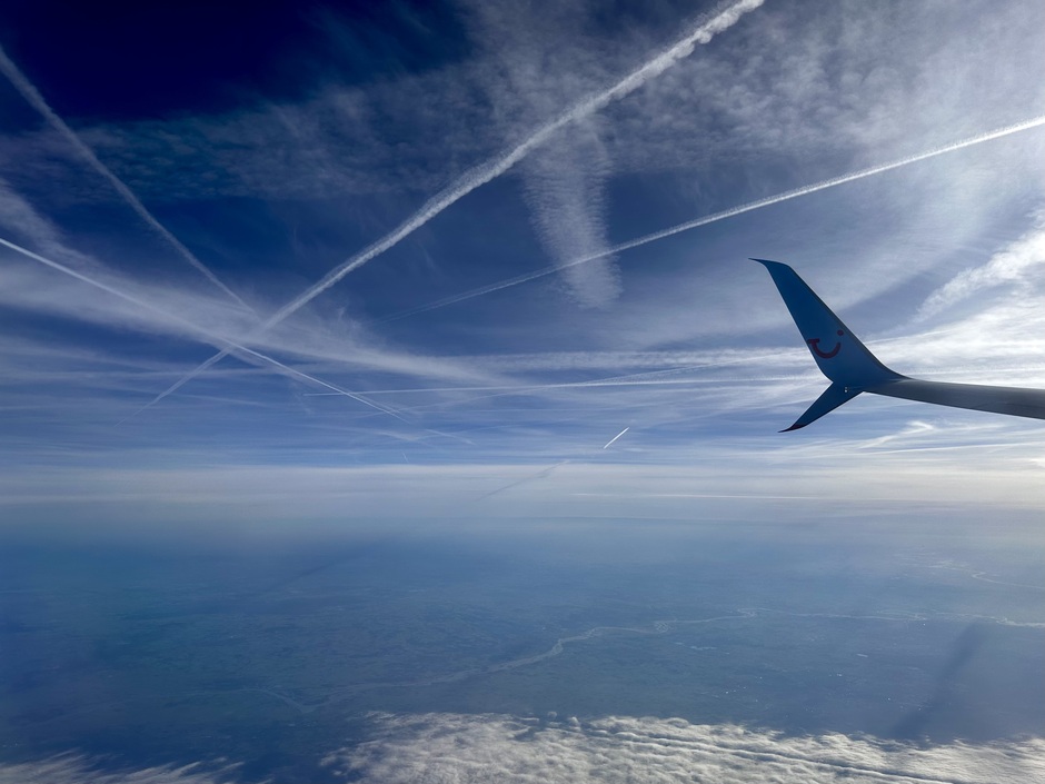 Vliegtuig strepen en lichte bewolking boven Noord Nederland begin van de middag vanuit vliegtuig prachtig zichtbaar