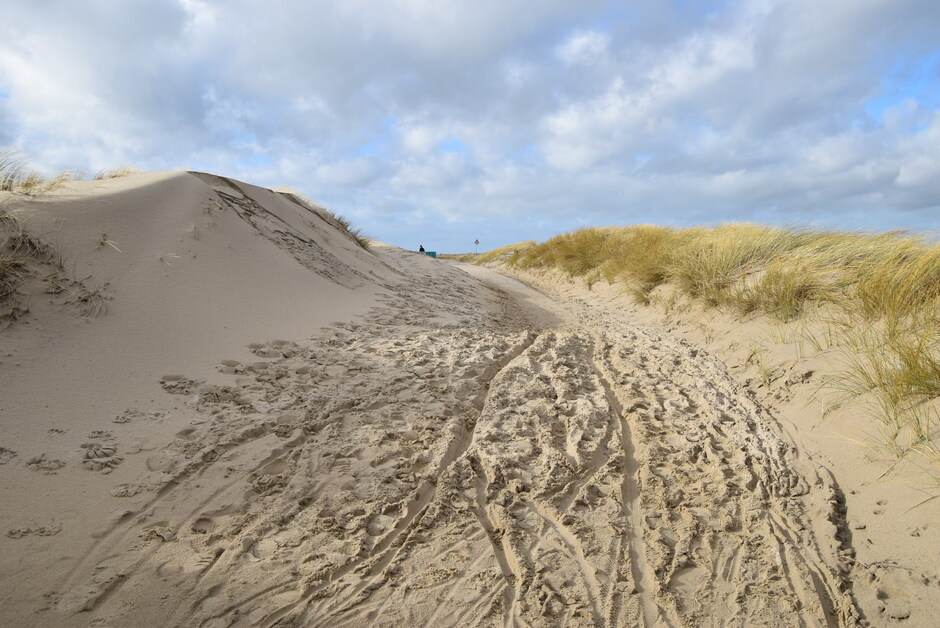 Wolken, zon, fietspad onder het zand