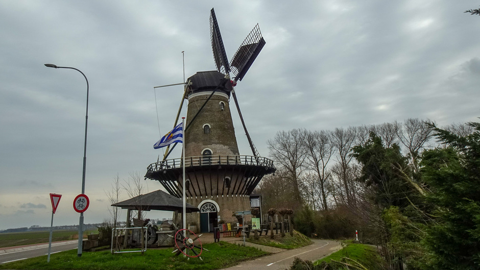 De zeeuwse vlag en de molen in de wind en bewolktelucht