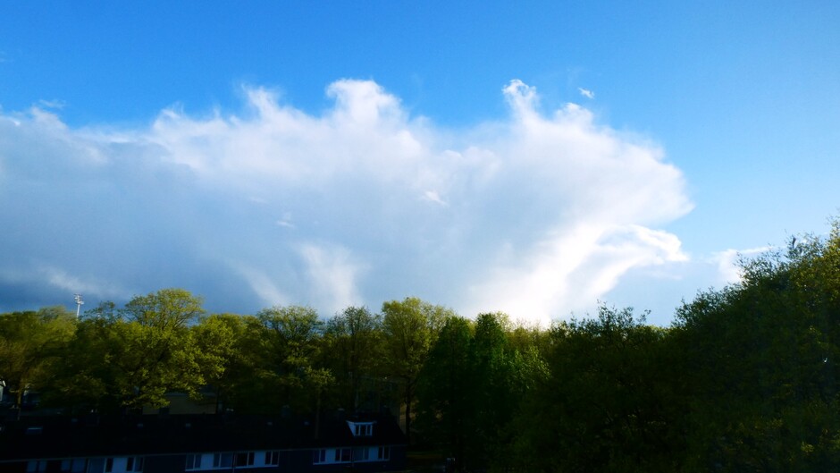 imposante buienwolken en buien met regenboog en opklaringen