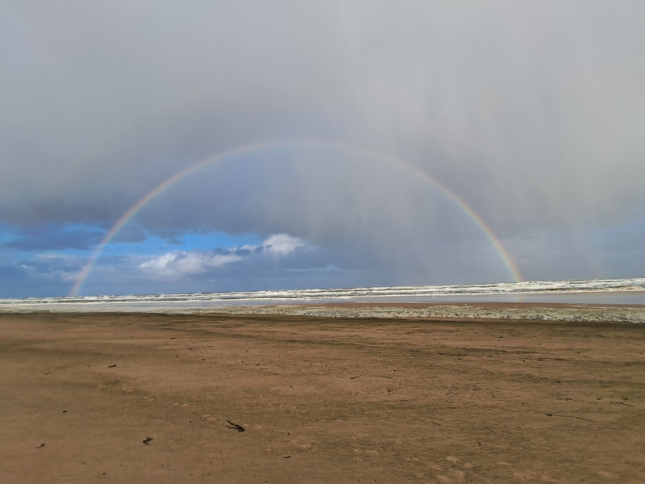 Prachtige weerfoto's strand met regenboog Castricum 