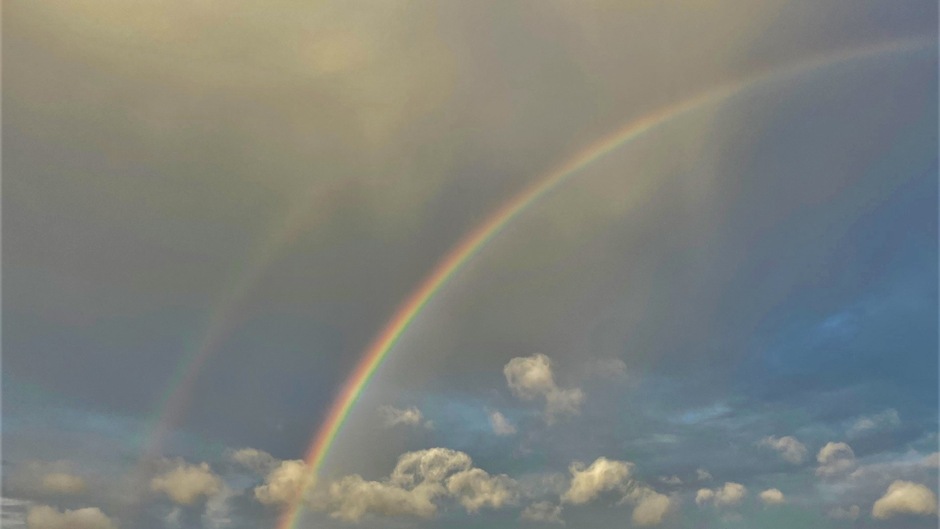 Hagelbui dubbele regenboog met hagelbui strakke windzak kust stapelwolken polder