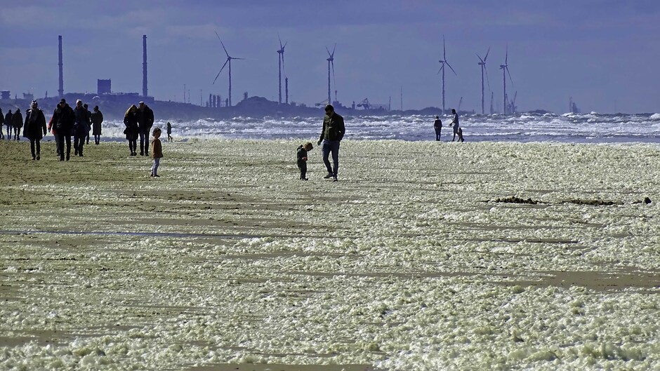Een strand vol zeeschuim en Hollandse luchten 